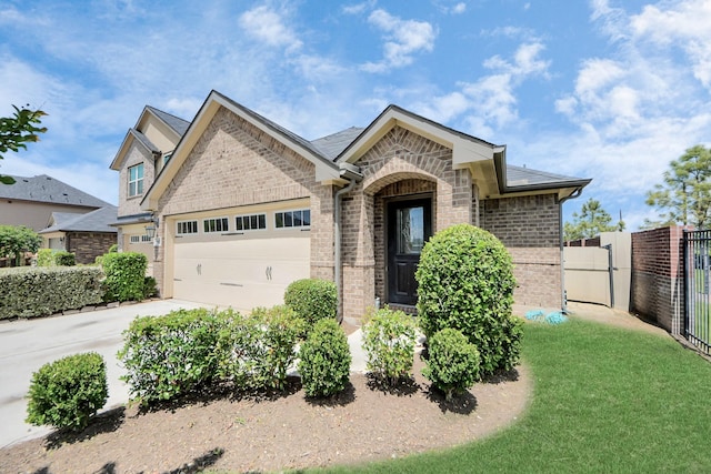 1404 Woods Lake Ct, Houston, TX 77047 - french country home with brick siding, a garage, concrete driveway, and stone siding