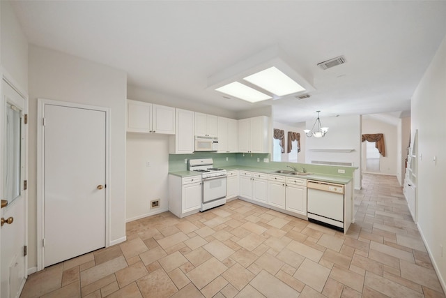 2920 Elm Grove Ct, Kingwood, TX 77339 - kitchen featuring white appliances, light countertops, a chandelier, white cabinetry, and a peninsula