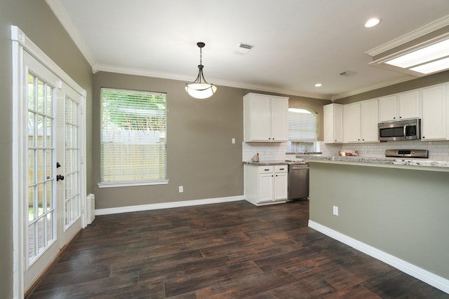 9111 Sutter Ranch Dr, Houston, TX 77064 - kitchen with stainless steel appliances, tasteful backsplash, white cabinetry, dark wood finished floors, and crown molding