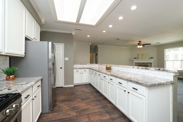 9111 Sutter Ranch Dr, Houston, TX 77064 - kitchen featuring gas range, a ceiling fan, ornamental molding, a fireplace, and decorative backsplash