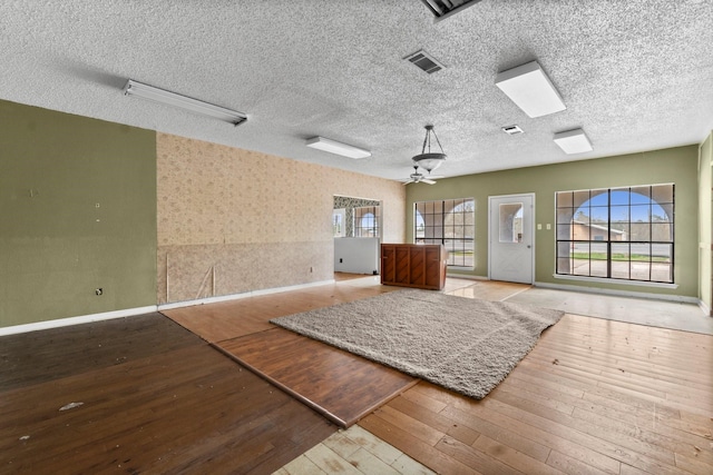 6738 US Highway 190 E, Livingston, TX 77351 - empty room with wood-type flooring, plenty of natural light, ceiling fan, and a textured ceiling