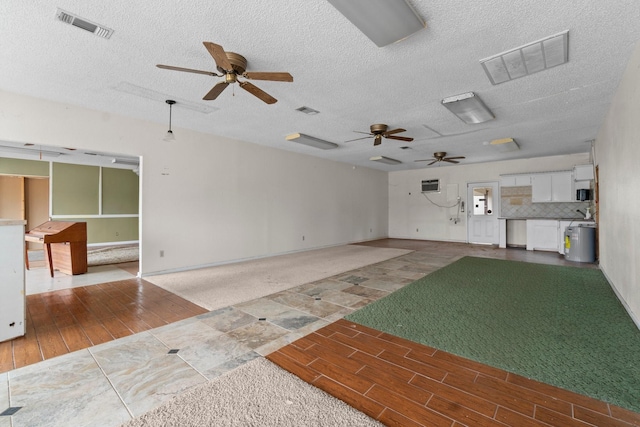 6738 US Highway 190 E, Livingston, TX 77351 - unfurnished living room featuring ceiling fan, wood finished floors, and a textured ceiling