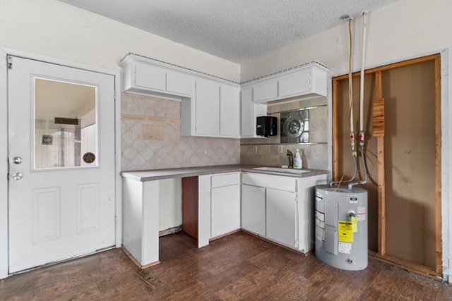 6738 US Highway 190 E, Livingston, TX 77351 - kitchen with electric water heater, dark wood finished floors, white cabinetry, backsplash, and a textured ceiling