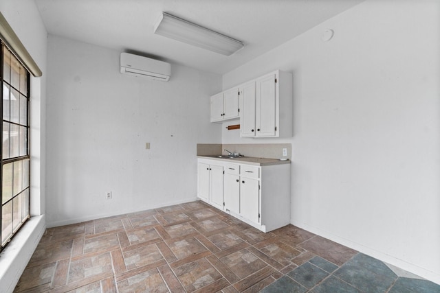 6738 US Highway 190 E, Livingston, TX 77351 - kitchen with a wall mounted air conditioner, white cabinets, and light countertops