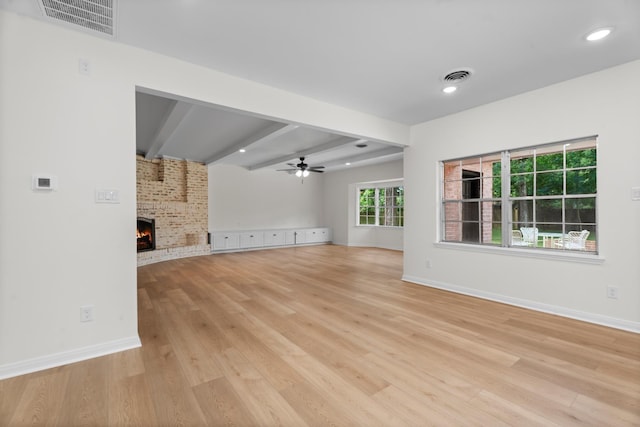 3 Briarwood Dr, Conroe, TX 77301 - unfurnished living room with light wood finished floors, a brick fireplace, ceiling fan, beamed ceiling, and recessed lighting