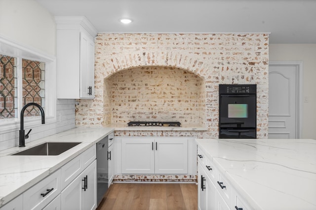3 Briarwood Dr, Conroe, TX 77301 - kitchen with wood finished floors, backsplash, white cabinets, light stone counters, and stainless steel appliances