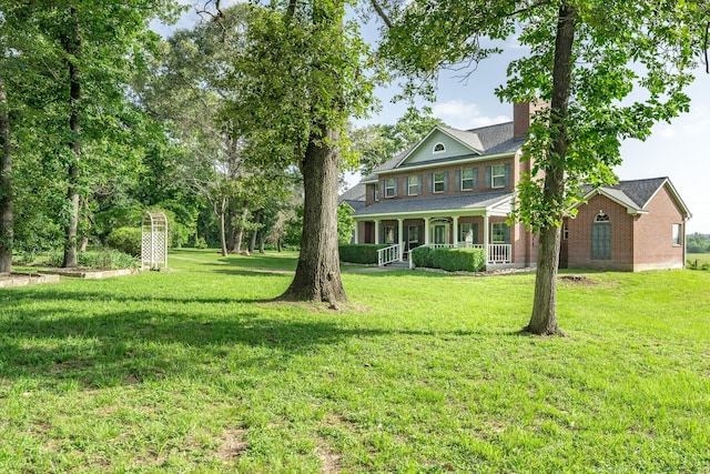 13141 Nicholson Rd, Conroe, TX 77303 - view of front of property featuring a porch, a front yard, a chimney, and brick siding