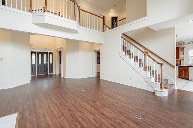 13141 Nicholson Rd, Conroe, TX 77303 - unfurnished living room featuring a towering ceiling, wood finished floors, ornamental molding, stairs, and plenty of natural light