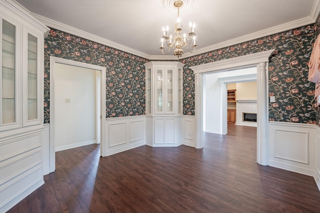 13141 Nicholson Rd, Conroe, TX 77303 - unfurnished dining area featuring a chandelier, wainscoting, wallpapered walls, a fireplace with flush hearth, and dark wood-style floors