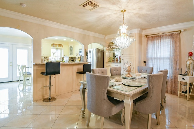 9411 Kingsvalley St, Houston, TX 77075 - dining space with arched walkways, a chandelier, crown molding, french doors, and light tile patterned floors