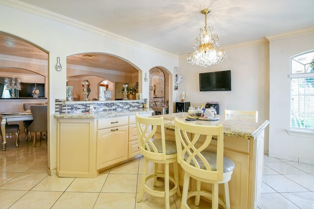 9411 Kingsvalley St, Houston, TX 77075 - kitchen with a chandelier, backsplash, arched walkways, crown molding, and light tile patterned floors