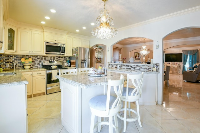 9411 Kingsvalley St, Houston, TX 77075 - kitchen featuring stainless steel appliances, a chandelier, backsplash, arched walkways, and crown molding