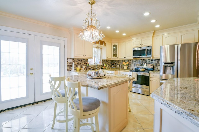 9411 Kingsvalley St, Houston, TX 77075 - kitchen featuring stainless steel appliances, decorative backsplash, light tile patterned flooring, light stone countertops, and a breakfast bar area