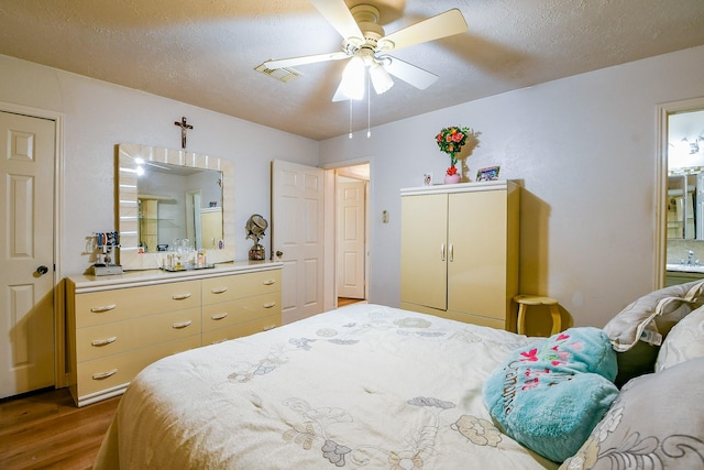 9411 Kingsvalley St, Houston, TX 77075 - bedroom featuring wood finished floors, a textured ceiling, and a ceiling fan