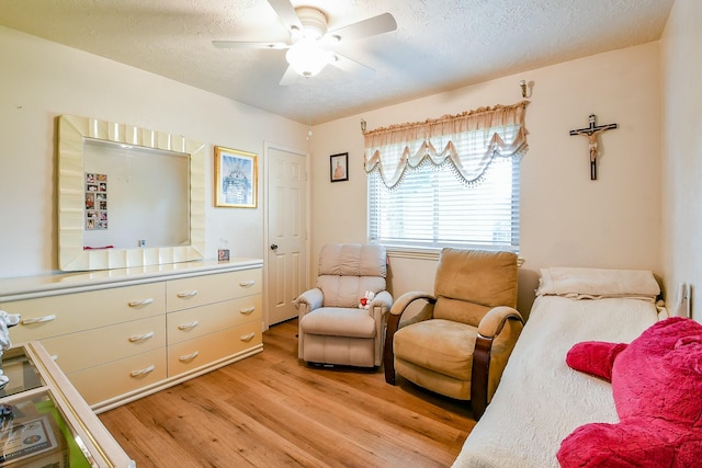 9411 Kingsvalley St, Houston, TX 77075 - sitting room with light wood-style floors, a ceiling fan, and a textured ceiling
