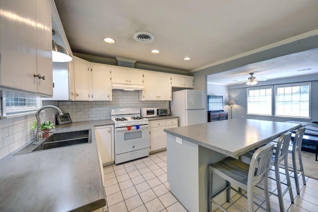 204 Meadow Ln, Brenham, TX 77833 - kitchen featuring white appliances, under cabinet range hood, ornamental molding, tasteful backsplash, and white cabinets