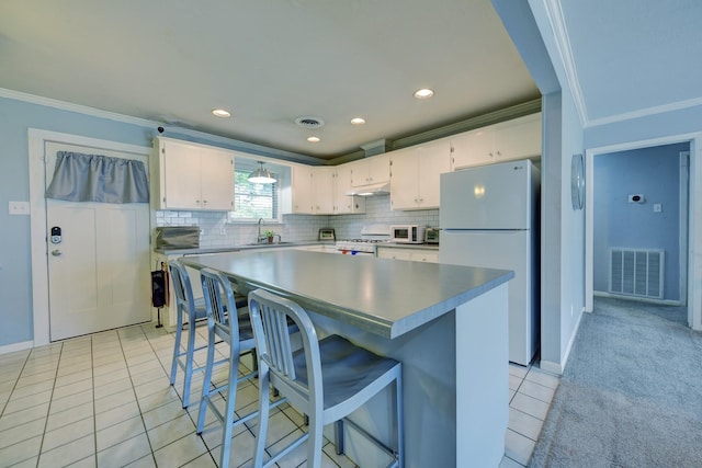 204 Meadow Ln, Brenham, TX 77833 - kitchen featuring freestanding refrigerator, range, ornamental molding, white cabinets, and backsplash