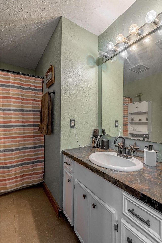 1205 W Houston Ave W, Crockett, TX 75835 - full bath with vanity, a textured wall, and a textured ceiling