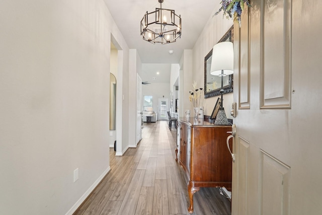 10126 Bayou Oaks Dr, Conroe, TX 77385 - hallway with a chandelier and light wood-type flooring