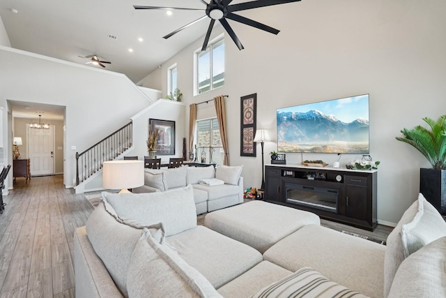 10126 Bayou Oaks Dr, Conroe, TX 77385 - living area with a ceiling fan, a chandelier, high vaulted ceiling, stairs, and light wood-style flooring
