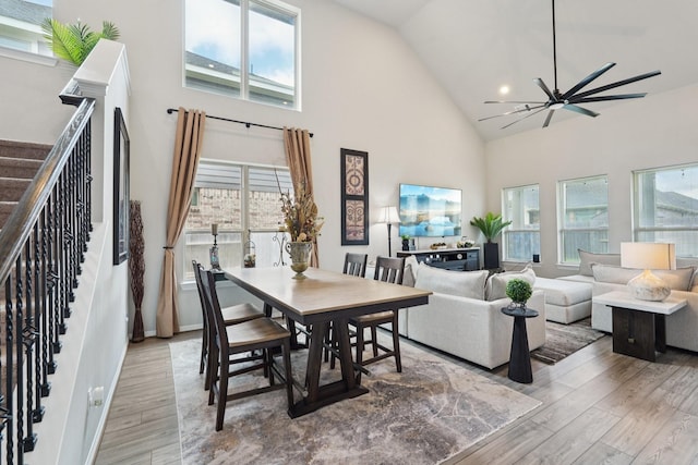 10126 Bayou Oaks Dr, Conroe, TX 77385 - dining area featuring high vaulted ceiling, wood finished floors, stairway, ceiling fan, and plenty of natural light