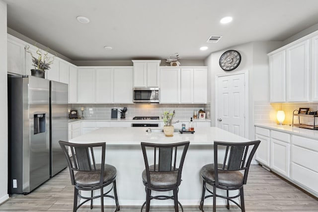 10126 Bayou Oaks Dr, Conroe, TX 77385 - kitchen featuring stainless steel appliances, light countertops, a kitchen island with sink, white cabinetry, and recessed lighting