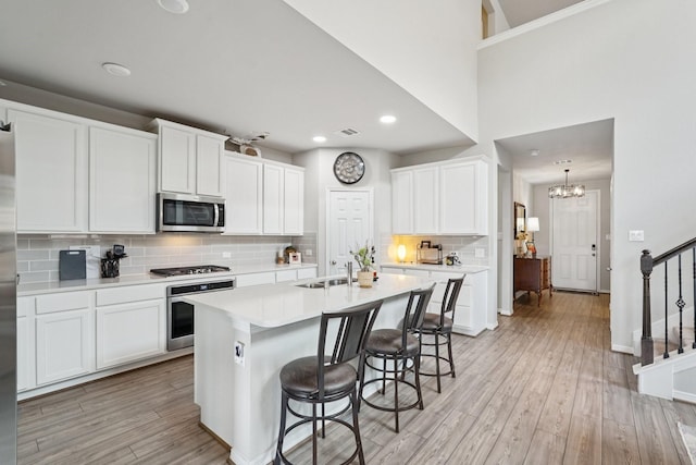 10126 Bayou Oaks Dr, Conroe, TX 77385 - kitchen featuring appliances with stainless steel finishes, a kitchen breakfast bar, tasteful backsplash, light countertops, and recessed lighting