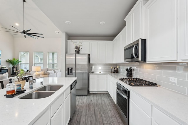 10126 Bayou Oaks Dr, Conroe, TX 77385 - kitchen featuring appliances with stainless steel finishes, tasteful backsplash, white cabinetry, and wood finished floors