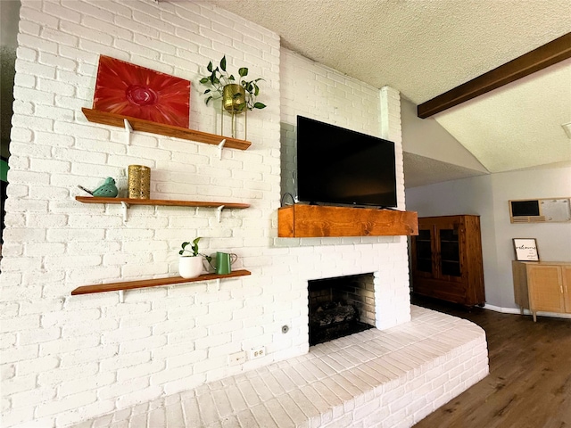 1006 Fairlane Dr, Ganado, TX 77962 - unfurnished living room featuring wood finished floors, a textured ceiling, a fireplace, and a wall mounted AC