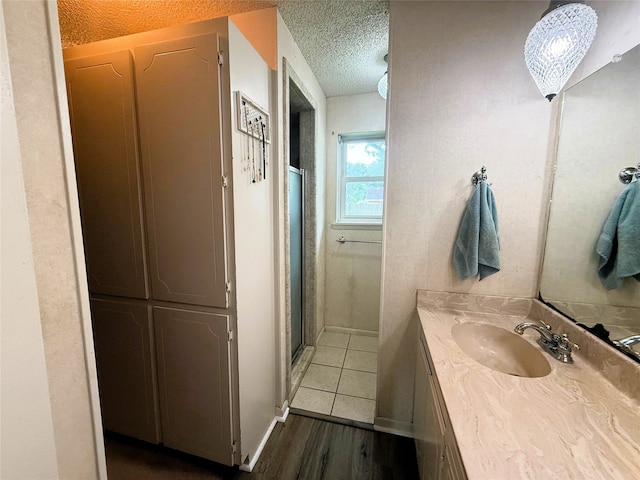1006 Fairlane Dr, Ganado, TX 77962 - full bathroom with a textured ceiling, vanity, wood finished floors, and a stall shower