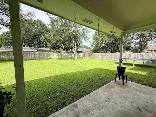 1006 Fairlane Dr, Ganado, TX 77962 - fenced backyard featuring a trampoline and a patio