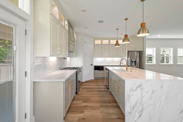 3224 Omega St, Houston, TX 77022 - kitchen featuring appliances with stainless steel finishes, backsplash, light wood-style flooring, glass insert cabinets, and recessed lighting