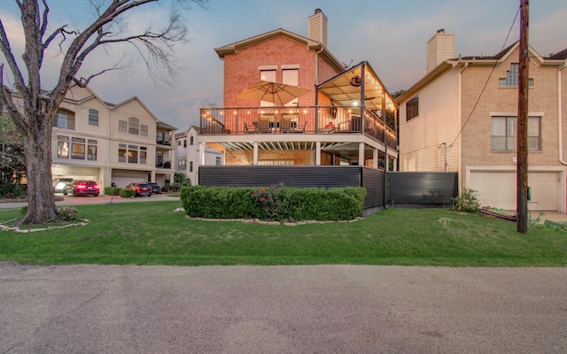 6205 Dell St, Houston, TX 77007 - back of property with brick siding, a balcony, a garage, a lawn, and a chimney