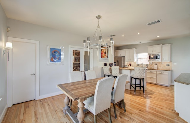 6205 Dell St, Houston, TX 77007 - dining area with a chandelier, light wood-style floors, and recessed lighting