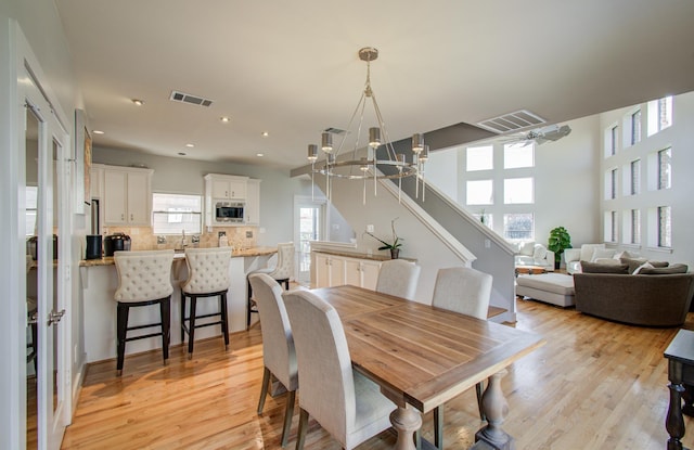 6205 Dell St, Houston, TX 77007 - dining space featuring a chandelier, light wood-style floors, stairway, and recessed lighting
