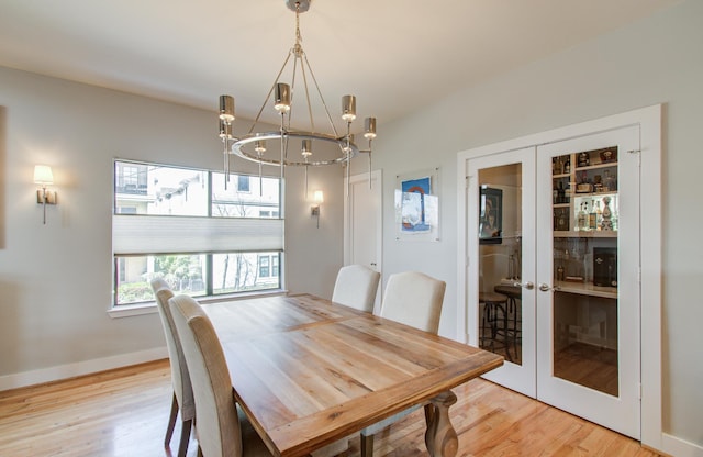 6205 Dell St, Houston, TX 77007 - dining space featuring french doors, light wood-type flooring, and a chandelier