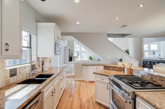 6205 Dell St, Houston, TX 77007 - kitchen with appliances with stainless steel finishes, healthy amount of natural light, light wood finished floors, light stone countertops, and recessed lighting