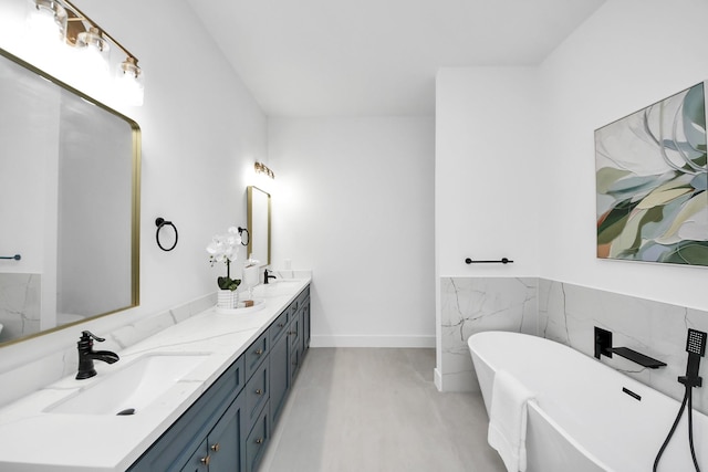 5520 Chapman St, Houston, TX 77009 - full bathroom featuring double vanity, a freestanding bath, wainscoting, and tile walls