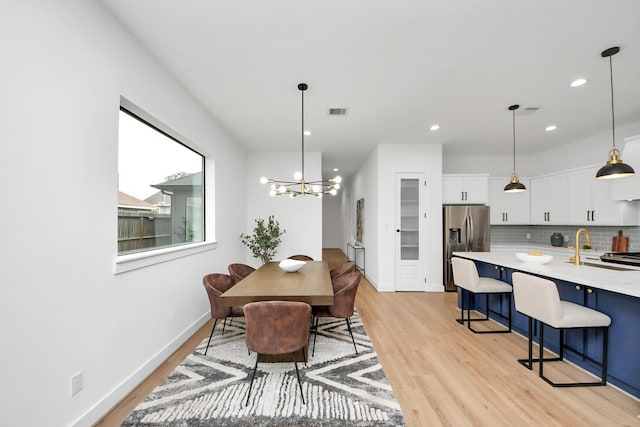 5520 Chapman St, Houston, TX 77009 - dining space with light wood-type flooring, recessed lighting, and a chandelier