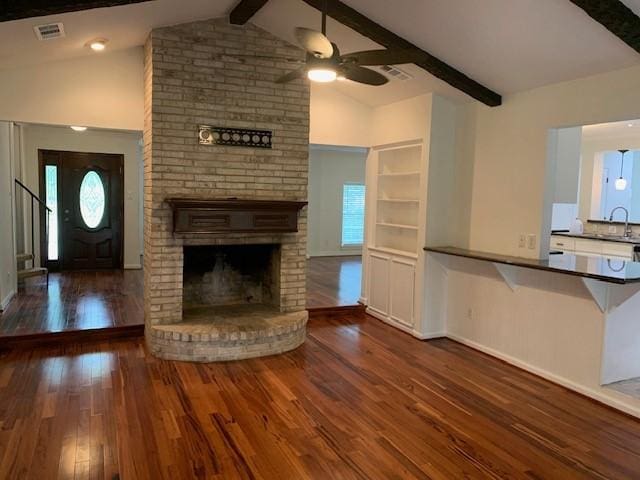 15025 Stagecoach Rd, Stagecoach, TX 77355 - unfurnished living room with ceiling fan, wood finished floors, beamed ceiling, a fireplace, and high vaulted ceiling