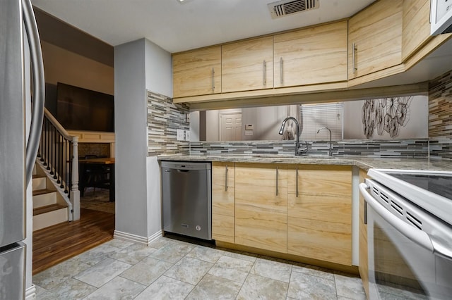 2601 Augusta Dr Unit 26, Houston, TX 77057 - kitchen featuring appliances with stainless steel finishes, tasteful backsplash, light brown cabinets, and light stone countertops