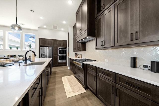 20210 Rolling Vista Dr, Cypress, TX 77433 - kitchen featuring appliances with stainless steel finishes, dark brown cabinetry, light wood-type flooring, backsplash, and recessed lighting