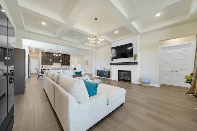 20210 Rolling Vista Dr, Cypress, TX 77433 - living area featuring coffered ceiling, light wood-style floors, a chandelier, a fireplace, and beam ceiling