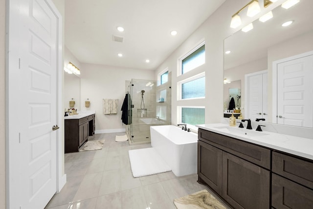 20210 Rolling Vista Dr, Cypress, TX 77433 - bathroom featuring a shower stall, two vanities, a freestanding tub, tile patterned floors, and recessed lighting