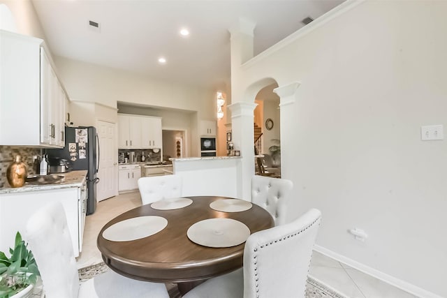 13719 Country Green Ct, Houston, TX 77059 - dining space with decorative columns, arched walkways, and light tile patterned flooring