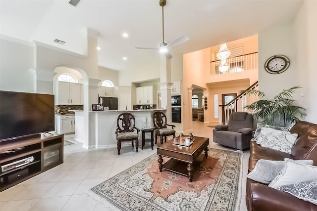 13719 Country Green Ct, Houston, TX 77059 - living area featuring ornate columns, light tile patterned flooring, a high ceiling, ceiling fan, and stairway
