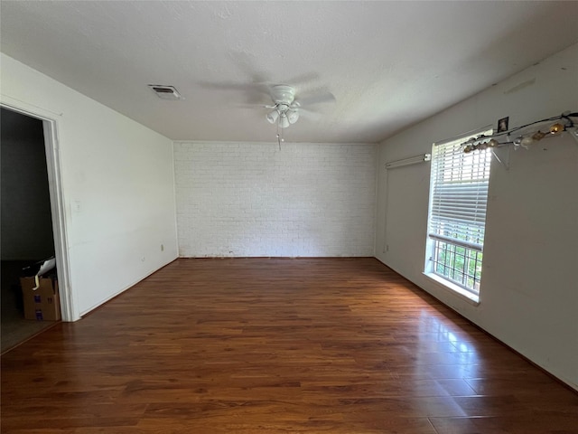 8330 Leamont Dr, Houston, TX 77072 - empty room featuring brick wall, a ceiling fan, and wood finished floors