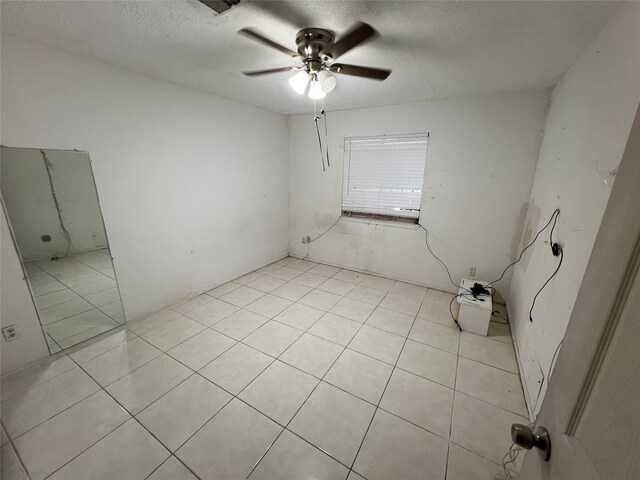 8330 Leamont Dr, Houston, TX 77072 - spare room with ceiling fan, light tile patterned floors, and a textured ceiling