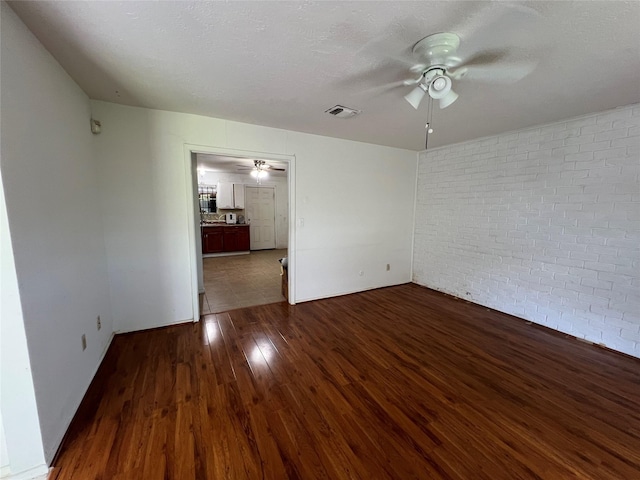 8330 Leamont Dr, Houston, TX 77072 - unfurnished room featuring ceiling fan, brick wall, and dark wood finished floors