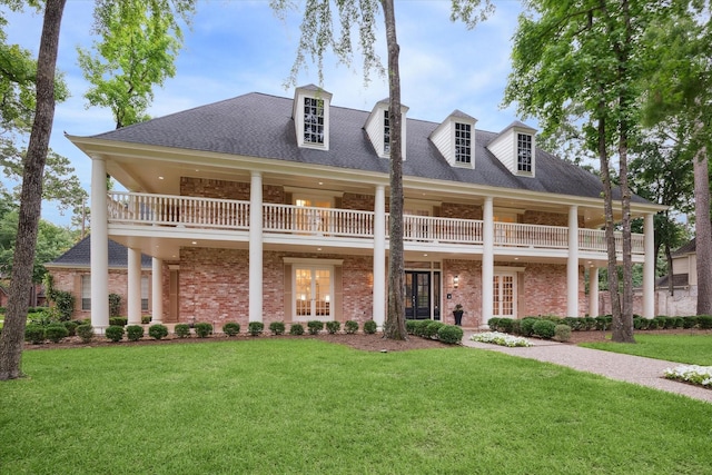 8703 Chelmsford Ln, Spring, TX 77379 - view of front of property featuring a front lawn, brick siding, a balcony, and a shingled roof